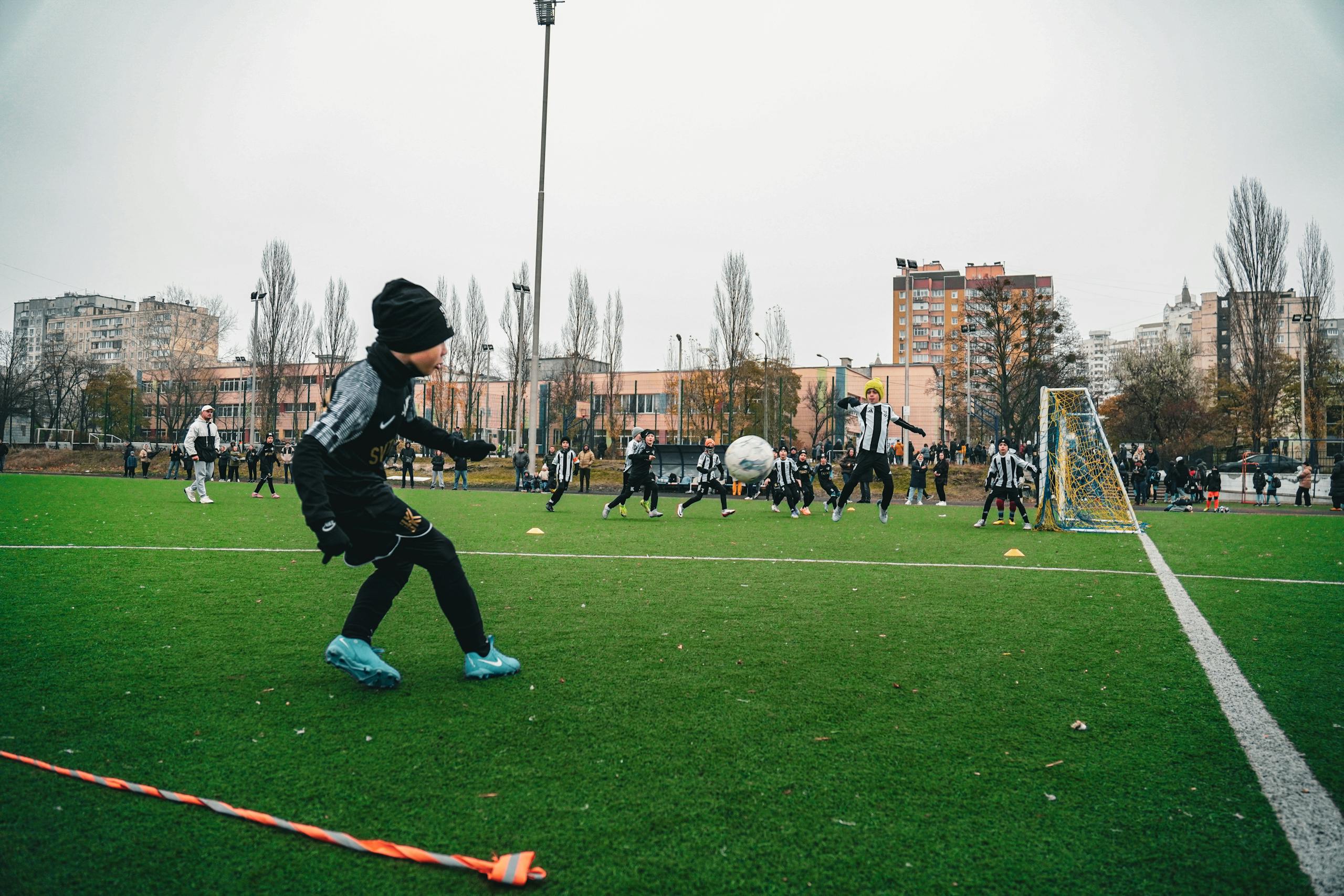 Kids playing soccer on an outdoor field in Kyiv, Ukraine, showcasing teamwork and sportsmanship.